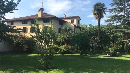 a house with a palm tree in a yard at Villa Della Stua in Cormòns