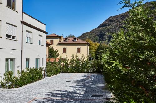 a path between two buildings with a mountain in the background at Appartamenti 1 in Dervio