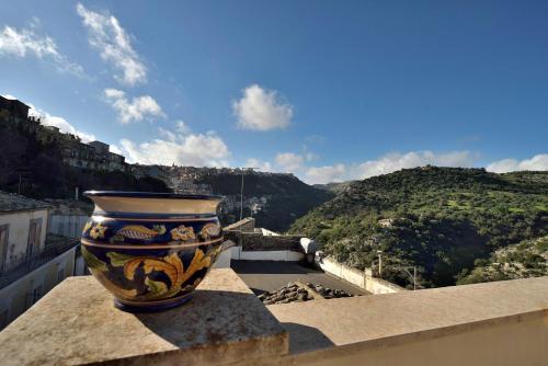 eine Vase auf einem Felsvorsprung mit Aussicht in der Unterkunft Le Luci su Ibla - Ospitalità con vista in Ragusa