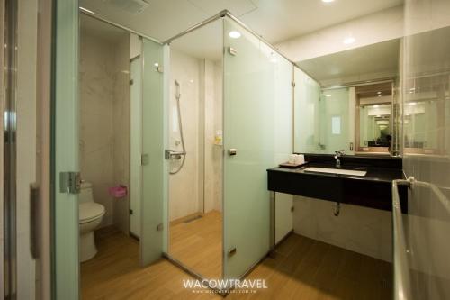 a bathroom with a sink and a toilet and a mirror at Venice Seaview Hotel in Xiaoliuqiu