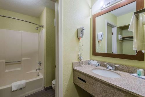 a bathroom with a sink and a shower and a phone at Quality Inn & Suites University Area in Muncie