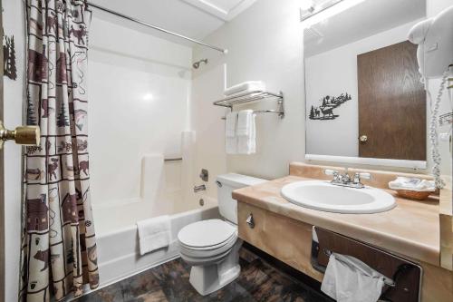 La salle de bains est pourvue d'un lavabo, de toilettes et d'un miroir. dans l'établissement Rodeway Inn Bryce Canyon, à Panguitch