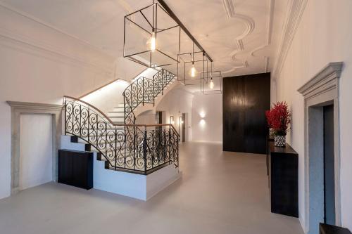 a staircase in a building with a chandelier at Castel Hörtenberg in Bolzano