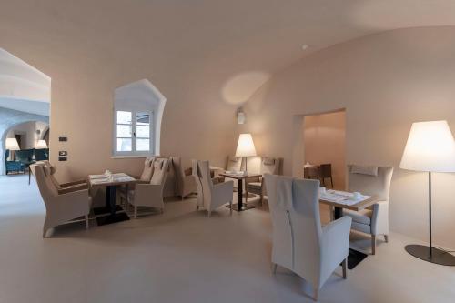 a dining room with white chairs and tables and a window at Castel Hörtenberg in Bolzano