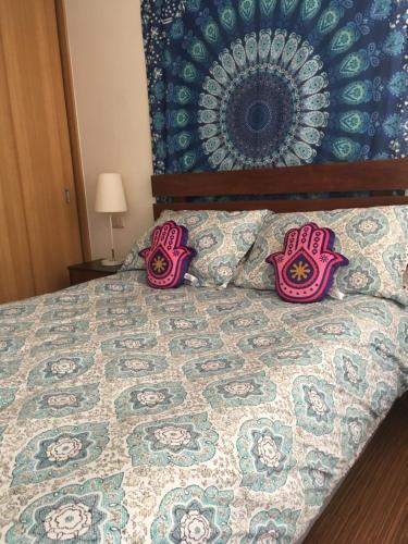 a bedroom with a bed with pink pillows on it at Buena Vista Zenteno in Santiago