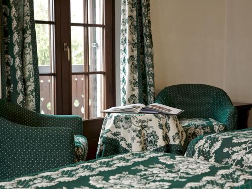 a room with two chairs and a table with a book at Hotel Milleluci in Aosta