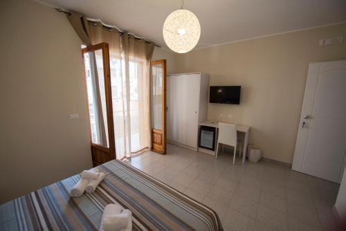 sypialnia z łóżkiem, biurkiem i telewizorem w obiekcie Donna Rosa Accommodation w Tropei