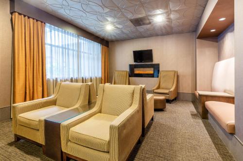 a waiting room with chairs and a flat screen tv at La Quinta by Wyndham Seattle Downtown in Seattle