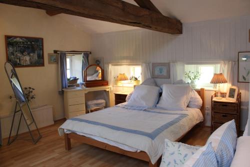a bedroom with a bed and a desk with a mirror at Charoul'Hôtes Gîtes et roulotte insolite in Saint-André-sur-Sèvre