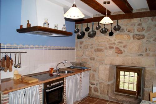 een keuken met een stenen muur bij Los Trashumantes in Molinos de Duero