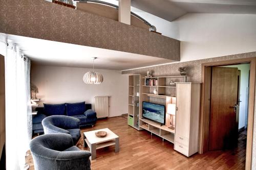sala de estar con 2 sillas azules y sofá en Apartments Jojo, en Bovec