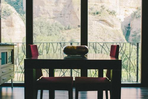 a table and chairs with a view of a mountain at Anahuaska Art - Suites Temáticas in Panzares