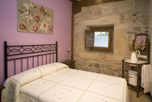 een slaapkamer met een bed en een stenen muur bij Los Trashumantes in Molinos de Duero