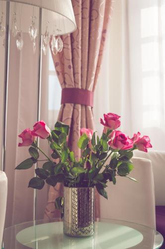 a vase with pink roses sitting on a table at Hotel Katerina in Znojmo