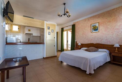 1 dormitorio con 1 cama y cocina en Apartamentos Mar y Sal en La Savina