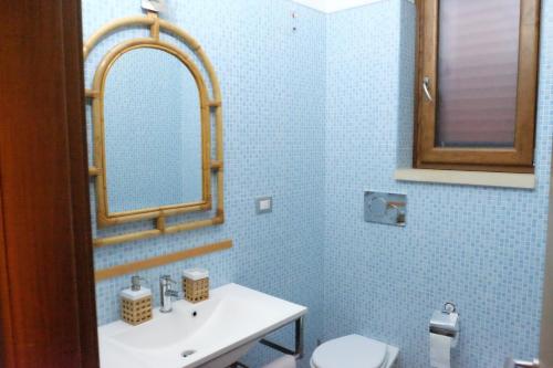 a bathroom with a sink and a mirror and a toilet at Dimora del Casale in Brindisi