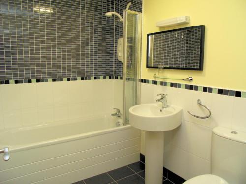 a bathroom with a sink and a tub and a toilet at Croft Mill in Hebden Bridge