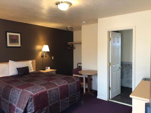 a hotel room with a bed and a table at Scottish Inn Winnemucca in Winnemucca