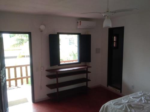 a bedroom with a bed and a window and a stairway at Hospedaria Cosanostra in Itaúnas