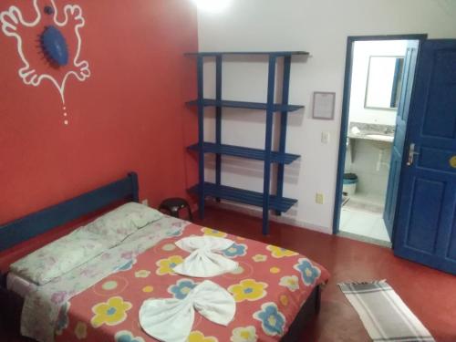 a bedroom with a bed and a blue door at Hospedaria Cosanostra in Itaúnas