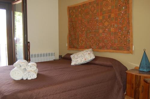 a bedroom with a bed with towels on it at Casa Cascabelera in Ayllón