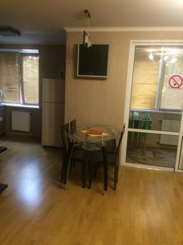uma sala de jantar com uma mesa de vidro e uma televisão em 1 комнатная квартира студио возле ТРЦ Днепроплаза em Cherkasy