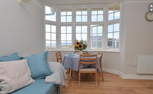 a living room with a table and a couch at Harbour View, Pier Terrace in West Bay