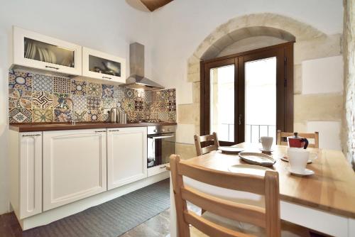 a kitchen with a wooden table and a dining room at Suite Piccolo Giavante in Ragusa
