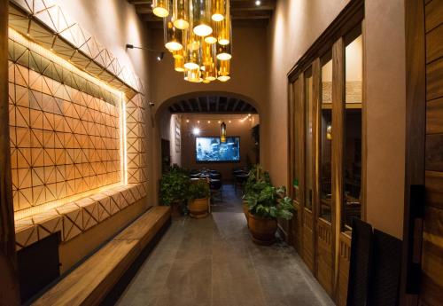 a hallway of a restaurant with benches and a chandelier at Casa Santiago Hotel Boutique in Querétaro