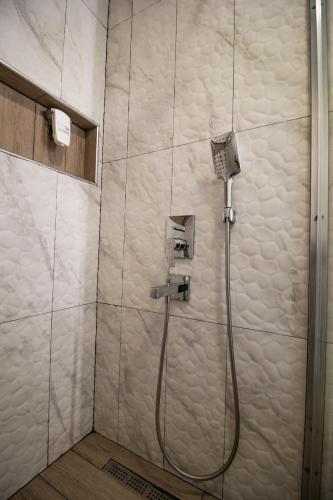a shower with a hose in a bathroom at Blue & White Hotel in Cıralı