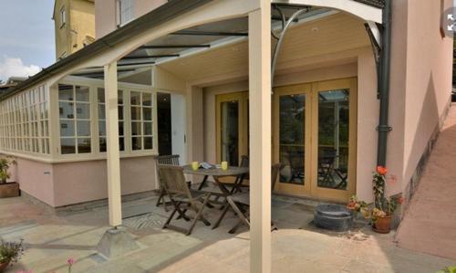 a patio with a table and chairs on a house at Little Wandas in Uplyme