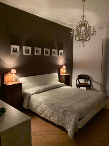 1 dormitorio con 1 cama, 2 mesas y lámpara de araña en Dimora del Casale, en Brindisi
