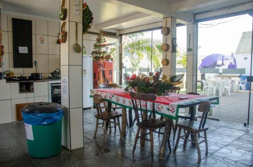 a kitchen with a table and some chairs and a counter at Pousada Aventura in Passo de Torres