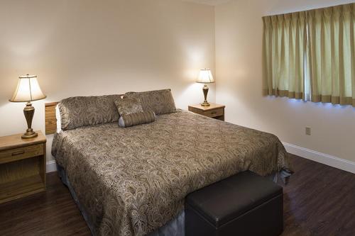 1 dormitorio con 1 cama grande y 2 lámparas en River Place Condos #508 2BD, en Pigeon Forge