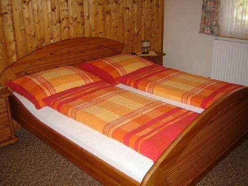 a wooden bed with a wooden headboard at Haus Waldblick in Auffach