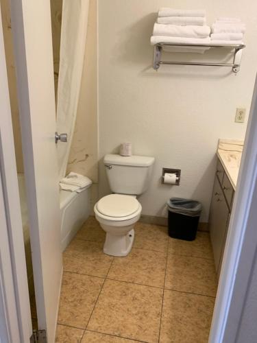 een badkamer met een toilet en een wastafel met handdoeken bij Desert Hot Springs Spa Hotel in Desert Hot Springs