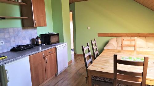 a kitchen with a wooden table and a table and chairs at Apartmány Sára in Tanvald