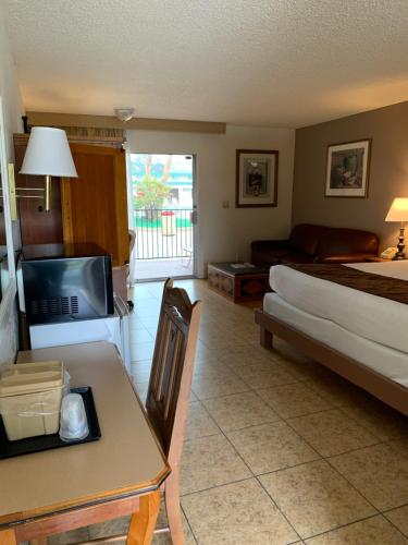 a hotel room with a bed and a table and a bed and a bed at Desert Hot Springs Spa Hotel in Desert Hot Springs