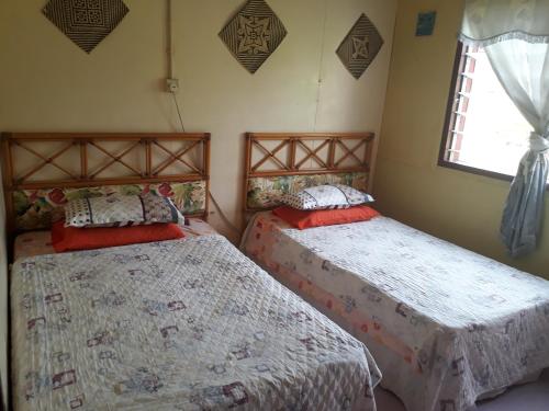 1 Schlafzimmer mit 2 Betten und einem Fenster in der Unterkunft Room 2 in Gunung Mulu Nationalpark