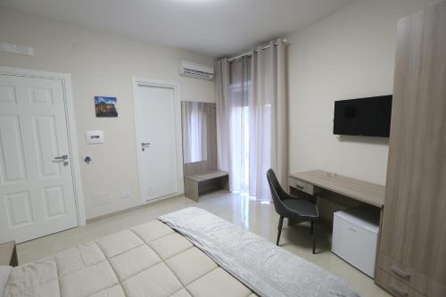 Habitación de hotel con cama, escritorio y TV. en COSTA APARTMENT NAPLES, en Nápoles
