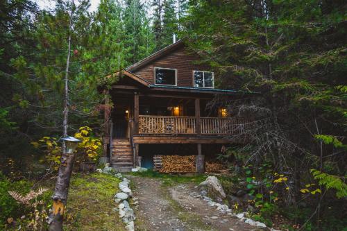 a log cabin in the woods with a path leading to it at Logden Lodge in Nelson