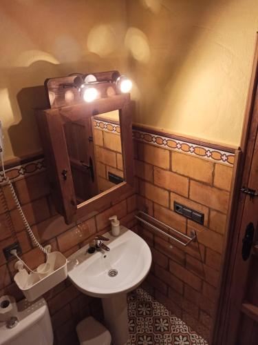 a bathroom with a sink and a mirror and a toilet at El Peñón in Zahara de la Sierra