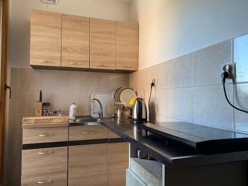 a kitchen with wooden cabinets and a black counter top at Janickowa Ostoja - Noclegi w Zakopanem in Zakopane