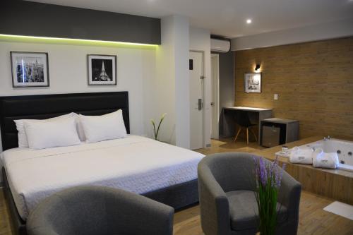 1 dormitorio con 1 cama, 2 sillas y escritorio en Awqa Concept Hotel, en Trujillo