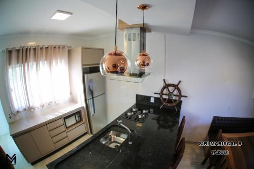a kitchen with a sink and a counter top at Siri Mariscal in Bombinhas