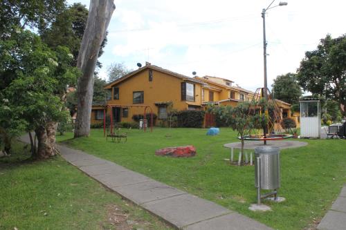 a house with a playground in the yard at Casa Posada Amelia in Bogotá