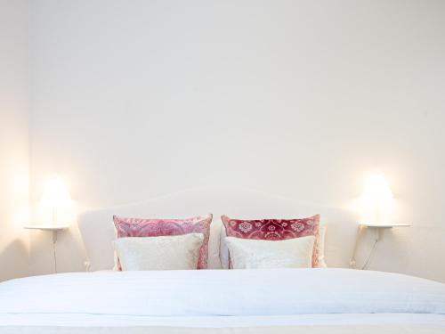 a bedroom with a white bed with four pillows at Family Apartment City Center Baden-Baden in Baden-Baden