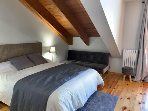 a bedroom with a large bed and a couch at Chalet Los Ibones - Lodge Formigal in Formigal
