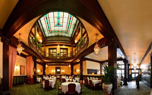 un comedor con mesas y un techo de vidrieras en Geiser Grand Hotel en Baker City
