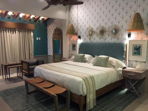 a bedroom with a large bed with a blue wall at Hotel Luxury Patio Azul in Puerto Vallarta